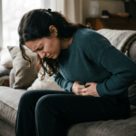 person with stomach pain from anxiety holding their gut in discomfort